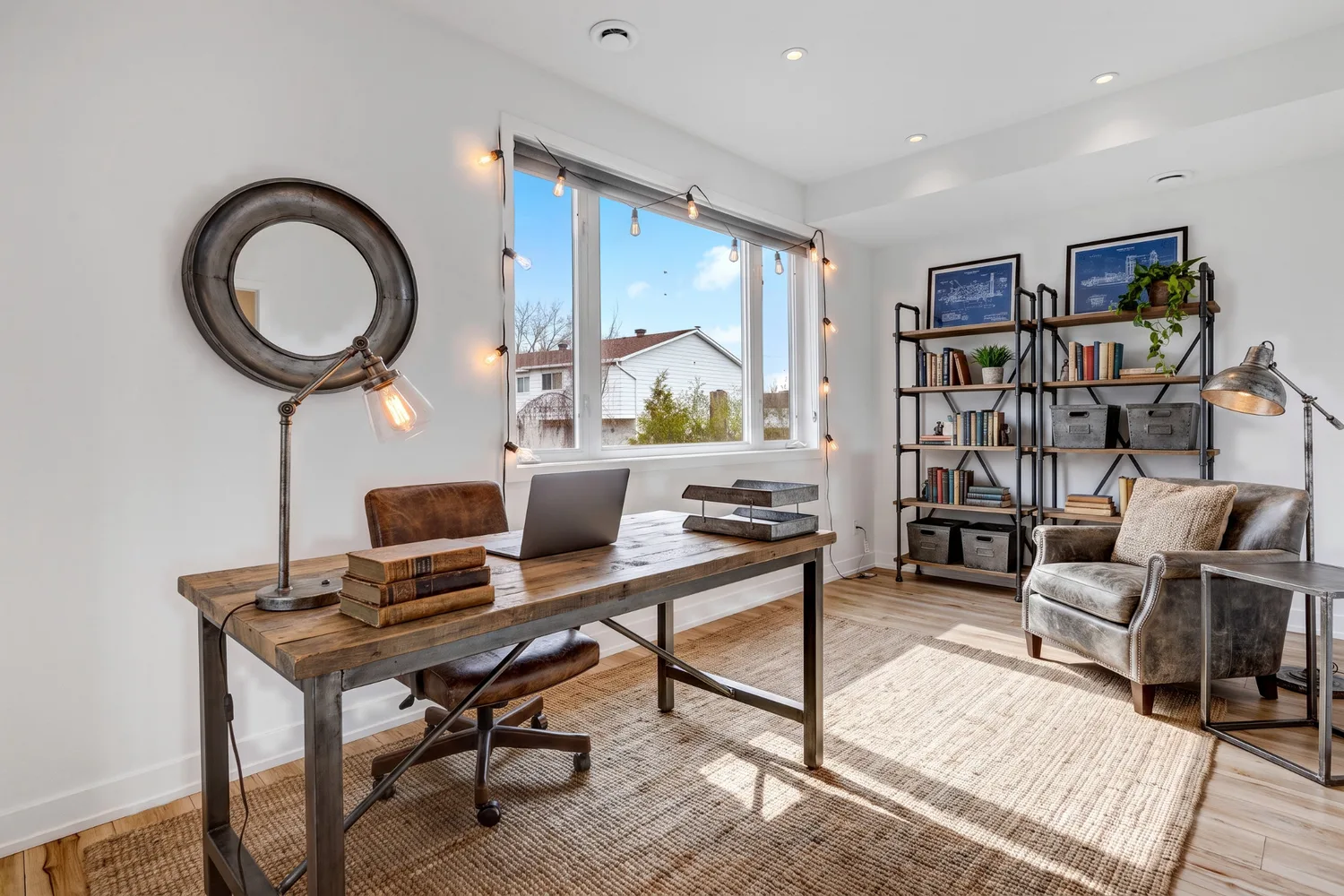 The same room furnished by RendScene as an industrial home office: wood-and-iron desk, shelving and a leather armchair
